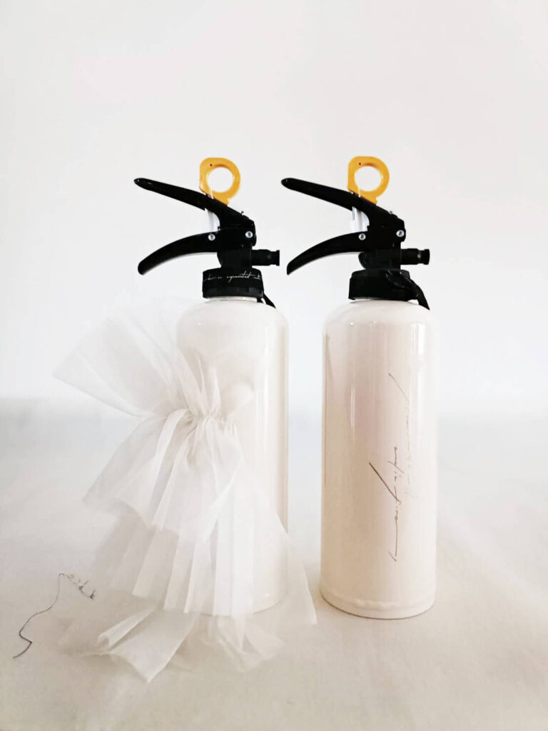 消火器背面。左の消火器には透け感のある白いチュールが結ばれている。